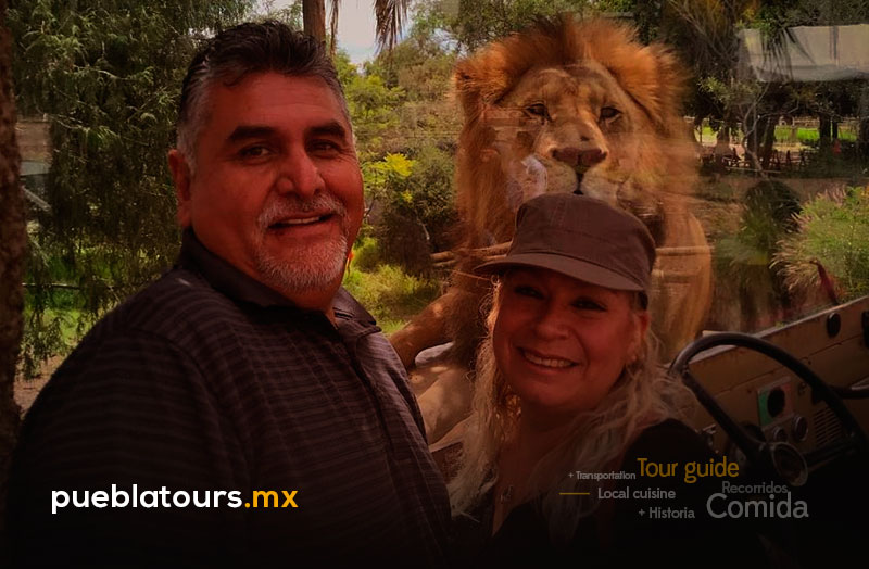 Pareja con león al fondo en Africam Safari Puebla