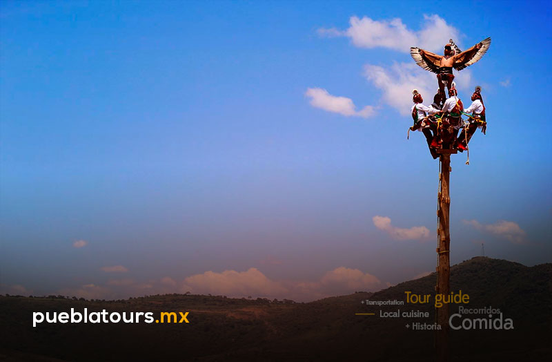 Danza de los Voladores en Atlixco sobre poste ceremonial contra el cielo azul