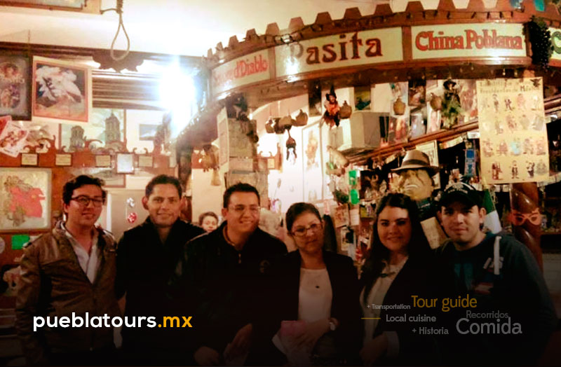 Grupo en La Pasita rodeado de botellas y recuerdos antiguos