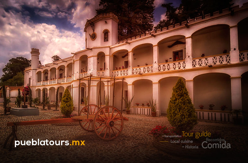 Fachada principal de la Ex Hacienda de Chautla con arcos coloniales y carreta antigua