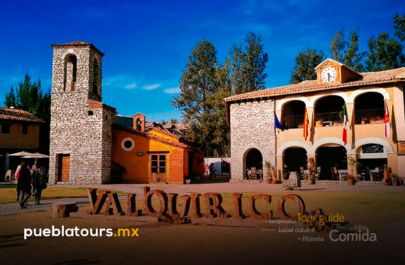 Plaza de Val’Quirico con letras monumentales y arquitectura de estilo toscano