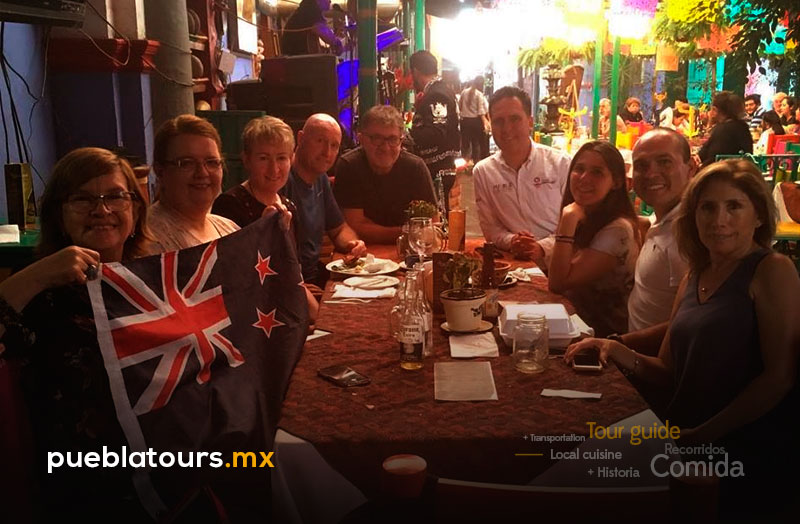 Grupo de viajeros degustando cena en restaurante de Puebla
