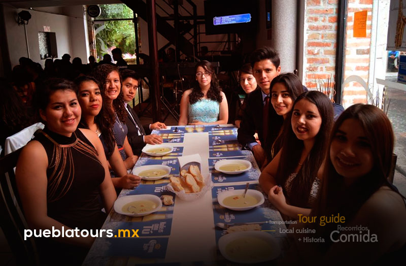 Amigas disfrutando menú poblano en mesa larga